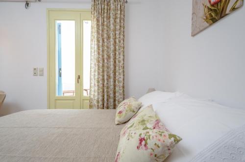 a bedroom with a bed with pillows and a window at Kapris House in Agios Prokopios