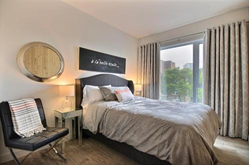 um quarto com uma cama, uma cadeira e uma janela em The City Life em Cidade de Quebec