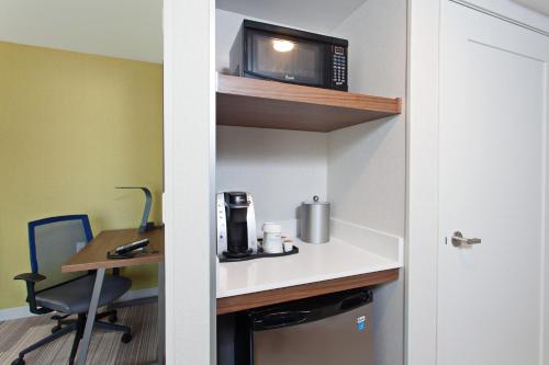 a small room with a desk and a microwave at Holiday Inn Express & Suites Pasadena - Los Angeles by IHG in Pasadena