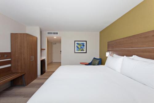 a hotel room with a large bed and a desk at Holiday Inn Express & Suites Pasadena - Los Angeles by IHG in Pasadena