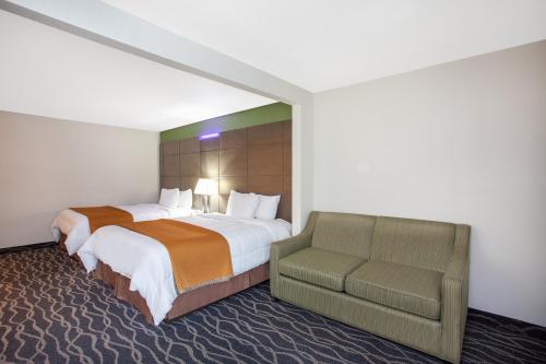 a hotel room with a bed and a chair at Travelodge Inn & Suites by Wyndham Anaheim on Disneyland Dr in Anaheim