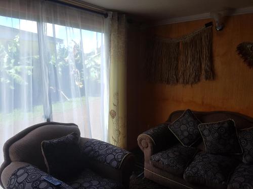 a living room with two chairs and a window at Cabaña Tongariki in Hanga Roa