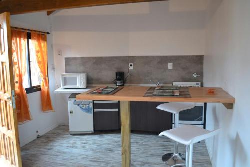 a kitchen with a wooden table and two stools at Duplex 7 Lunas in Villa Gesell