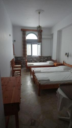 a room with three beds and a window at Kallirroi Studios in Pythagoreio