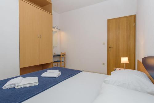 - une chambre avec un lit et 2 serviettes dans l'établissement apartmani Ivana, à Kaštela
