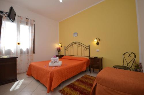 サン・ヴィート・ロ・カーポにあるtre passi dal mareのベッドルーム1室(オレンジのシーツを使用したベッド2台付)