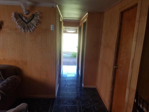 a hallway with a door leading to a room with a hallwayngthngthngthngth at Cabaña Tongariki in Hanga Roa