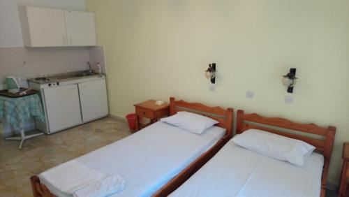 two beds in a small room with a kitchen at Kallirroi Studios in Pythagoreio