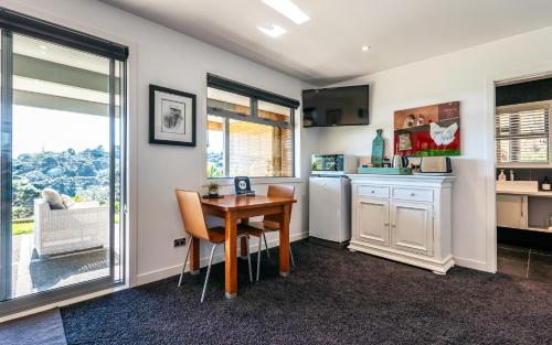 a kitchen with a table and chairs and a counter at Wild Thyme in Oneroa