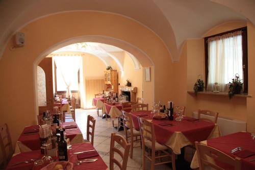 a restaurant with tables and chairs with red tablecloths at Albergo Casavecchia in Tiarno di Sopra