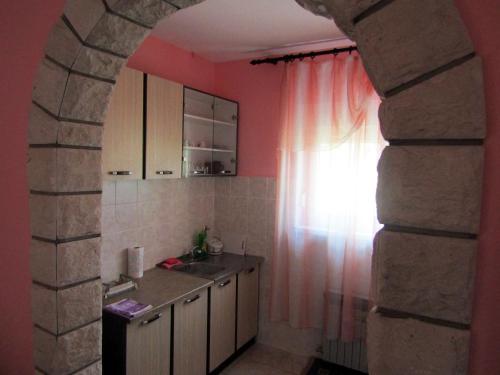 cocina con fregadero y ventana en Apartmani Lovro, en Ogulin