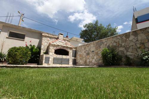 a house with a stone wall and a yard at Ninkovic in Trebinje