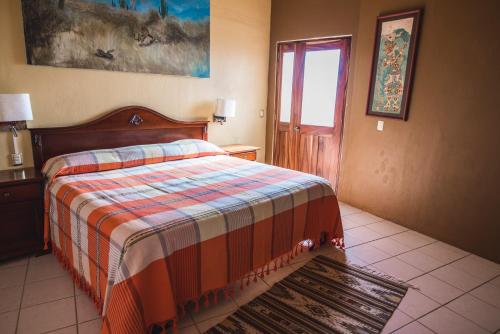 a bedroom with a bed and a window and a door at La Cupula B&B Teotitlan in Teotitlán del Valle