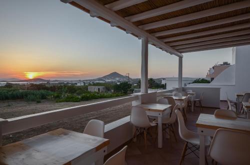 a restaurant with tables and chairs and a sunset at Margaritari Hotel in Agia Anna Naxos