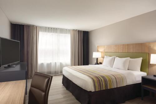 a hotel room with a bed and a television at Country Inn & Suites by Radisson, Chattanooga-Lookout Mountain in Chattanooga