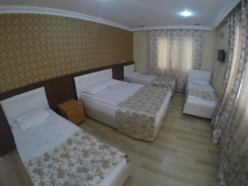 a hotel room with three beds and a couch at Pınar Vintage House in Pamukkale