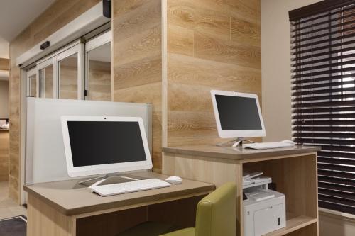 two computer monitors on a desk with a chair at Country Inn & Suites by Radisson, Chattanooga-Lookout Mountain in Chattanooga