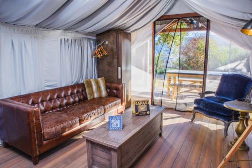 a living room with a brown leather couch and a table at Flying Flags RV Resort & Campground in Buellton