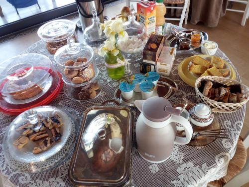 Country House Erba Regina في فراسكاتي: طاولة مليئة بأطباق الطعام والحلويات