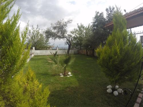 a backyard with a yard with trees and a fence at Pınar Vintage House in Pamukkale