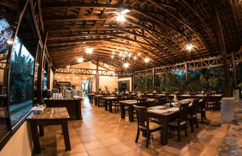 un restaurante con techos de madera, mesas y sillas en Paradise Hot Springs en Fortuna
