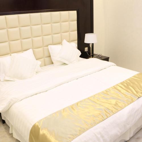 Tempat tidur dalam kamar di فخامة الريان للشقق المخدومة
