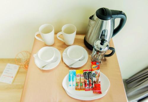 a table with two plates and cups and a tea kettle at Be My Guest 36 in Bangkok