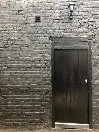 a black door on a brick wall with a street light at Luxury Apartment in Blackpool