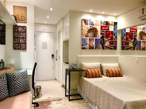a bedroom with a bed and a table and posters at Studio Augusta in Sao Paulo
