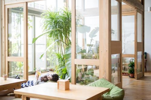 a person laying on the floor in a room with plants at Star Hostel Taipei Main Station in Taipei