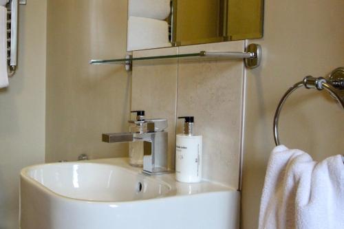 a white sink in a bathroom with a towel at The Badger Inn in Church Minshull