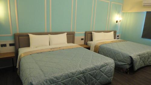 a hotel room with two beds in a room at Travel Port Motel in Kaohsiung