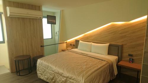 a hotel room with a bed and a window at Travel Port Motel in Kaohsiung