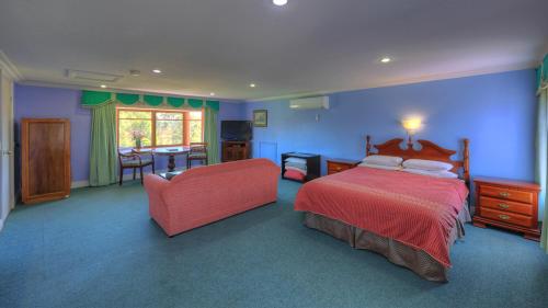 a bedroom with blue walls and a bed and a chair at Hatchers Richmond Manor in Richmond