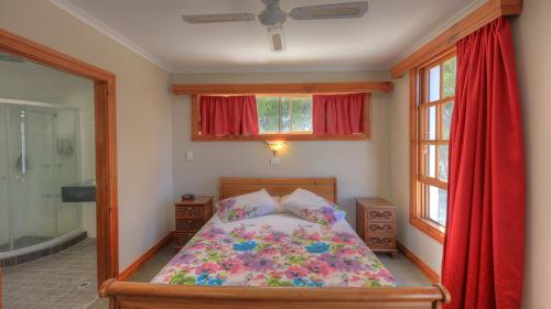 a bedroom with a bed and two windows and a shower at Hatchers Richmond Manor in Richmond