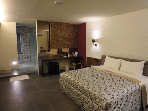 a hotel room with a bed and a desk at Travel Port Motel in Kaohsiung