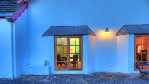 a white building with a glass door with a table at Hatchers Richmond Manor in Richmond