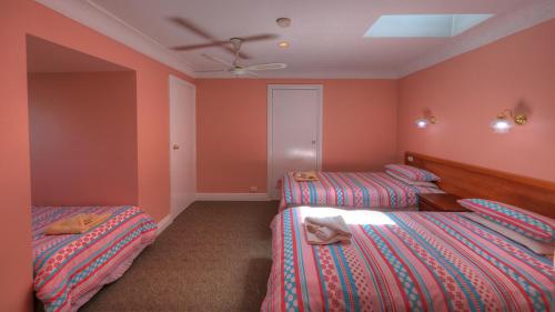 two beds in a room with orange walls at Hatchers Richmond Manor in Richmond