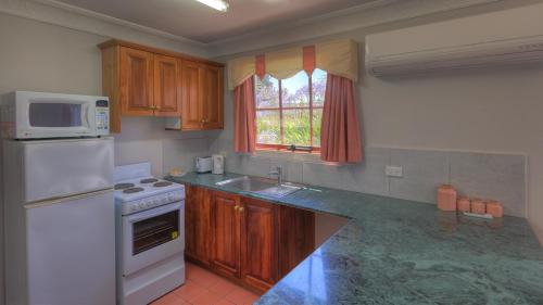 a kitchen with a white refrigerator and a microwave at Hatchers Richmond Manor in Richmond