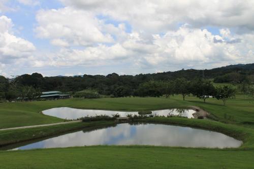 a view of a golf course with a pond at Summit Rainforest Golf Resort & All Inclusive in Paraíso
