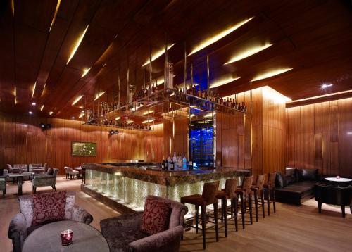 a bar in a restaurant with a bunch of chairs at Taj City Centre Gurugram in Gurgaon