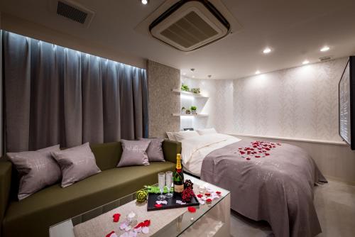 sypialnia z łóżkiem i kanapą z różami w obiekcie Restay Onoji (Adult Only) w mieście Machida