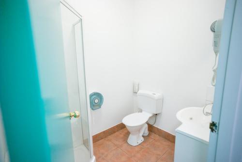 a white bathroom with a toilet and a shower at YHA Hobart Central in Hobart