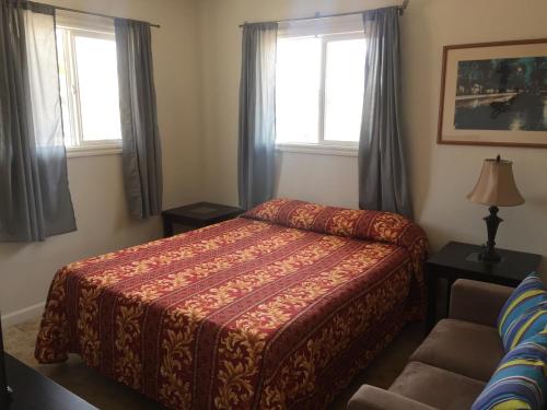 - une chambre avec un lit, un canapé et deux fenêtres dans l'établissement The Shores Inn, à Ventura