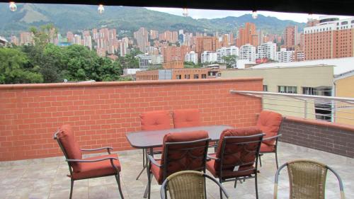 d'une table et de chaises sur un balcon avec vue sur la ville. dans l'établissement The 9's Apartahotel, à Medellín