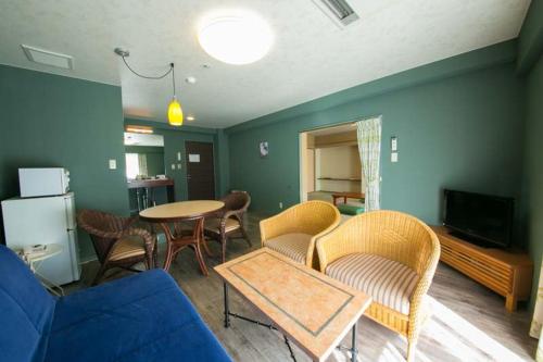 a living room with a couch and a table and chairs at Sundance Resort Hakone Miyagino in Hakone