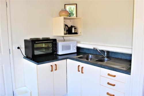 a kitchen with a microwave and a sink at Zen Two-Bedroom Unit in Rotorua