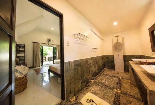 y baño con ducha de piedra y lavamanos. en Cabilao Sanctuary Beach & Dive Resort en Loon