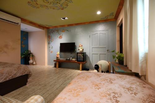 a bedroom with a bed and a tv and a door at Sweet Heart B&B in Jian