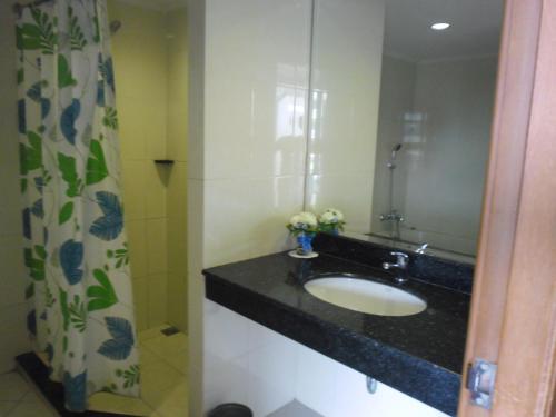 a bathroom with a sink and a mirror at Hatyai Paradise Hotel & Resort in Hat Yai